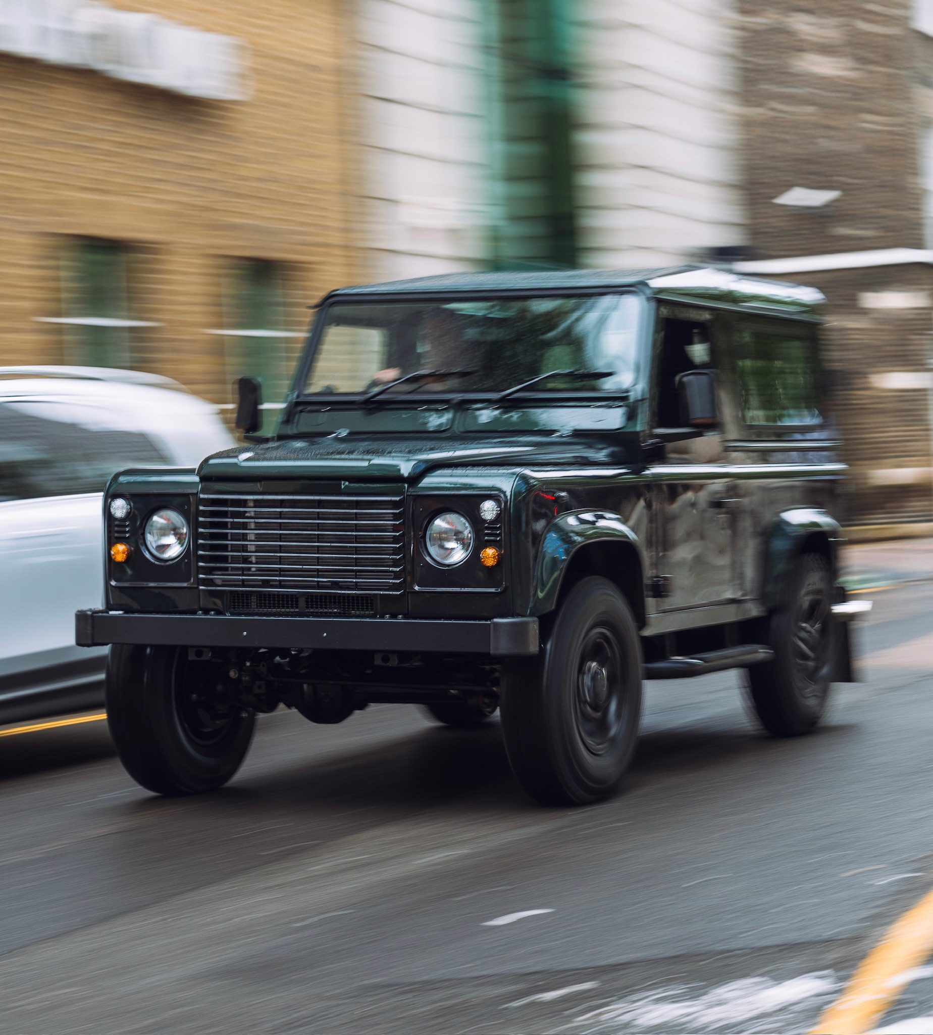 A Series Land Rover in motion on a country road